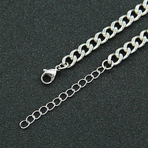 Close-up of silver metal Cuban chain with lobster clasp and extension on black background