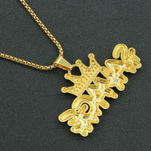 Close-up of hip hop gold crown letter pendant on a square link box chain