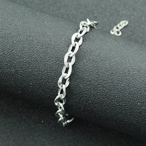 Minimalist silver stainless steel cable chain bracelet shown on a cylindrical display stand