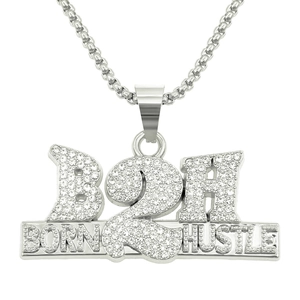 Gros plan du pendentif hip hop argenté avec cristaux B2H et gravure Born Hustle sur base