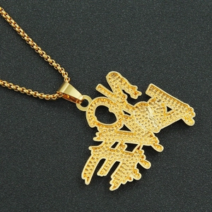 Détail du pendentif lettre dorée sertie de strass sur une chaîne à mailles carrées
