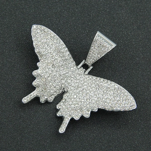 Gros plan du pendentif papillon argenté serti de cristaux brillants style hip-hop