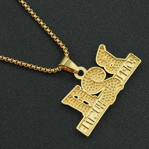 Détail macro du pendentif Born To Hustle 2000 plaqué or avec chaîne maille miroir