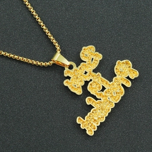 Vue macro du pendentif Richie Rich avec lettres scintillantes et chaîne box dorée