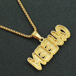 Détail du pendentif lettre MEOUQ doré avec finition texturée et chaîne à mailles box