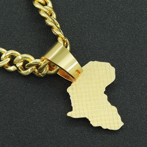 Gros plan du pendentif carte de l'Afrique doré avec texture sur une chaîne cubaine