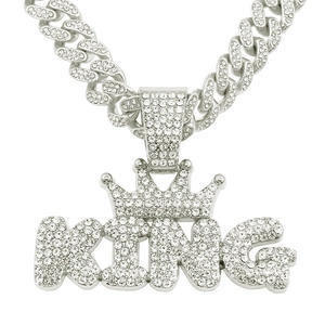 Macro shot of iced out silver KING crown pendant with shimmering cubic zirconia stones