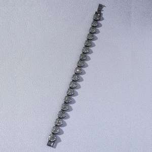 Gros plan sur un bracelet hip-hop en forme de cœur avec strass gris sur cuir violet