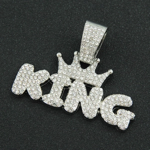 Macro shot of iced out silver KING pendant with crown and shimmering cubic zirconia