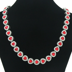 Detailed view of red heart crystal necklace with white rhinestones on a black bust display