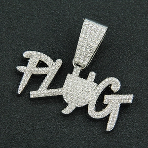 Détail du pendentif PLUG argenté orné de strass blancs brillants style hip-hop