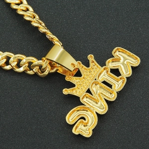 Close-up of gold iced out KING pendant with crown and chunky Cuban link chain