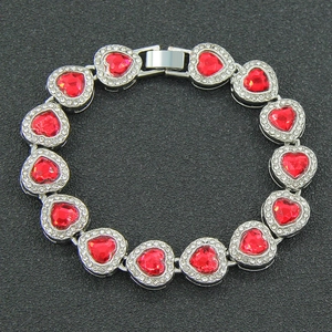 Macro shot of silver-plated heart bracelet with red rhinestones and pave zircon detail