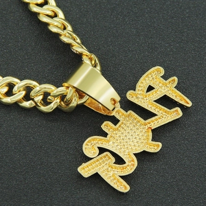 Gros plan détaillé du pendentif TRAP doré avec une texture glacée micro-pavée