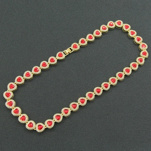 Glittering hip hop necklace featuring red rhinestone heart charms in gold finish