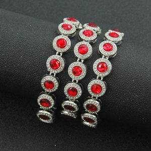 Dettaglio di tre bracciali argento con cristalli rossi centrali e pavé di zirconi bianchi