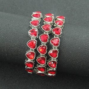 Close-up of triple-row red heart gemstone bracelet with polished silver metal setting