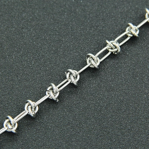 Macro shot of silver thorn knot link necklace with industrial punk style metal texture