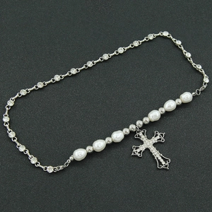 Baroque hollow cross pendant necklace with rhinestones and white pearls on black background