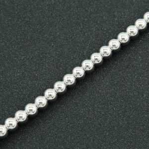 Macro detail of high-polish silver bead chain necklace with mirror-like metallic finish