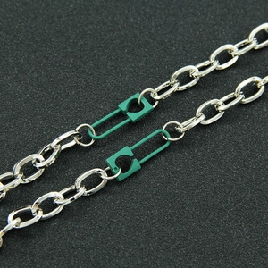 Collier chaîne argentée minimaliste avec breloques épingles à nourrice vertes en macro