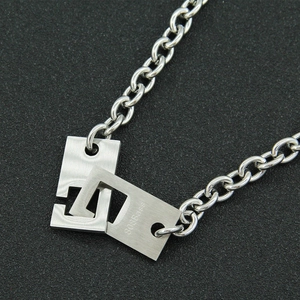 Industrial stainless steel interlocking rectangle pendant necklace on textured background