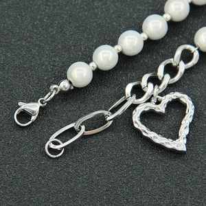 Detail of pearl splicing chain with lobster clasp and textured heart pendant detail
