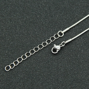 Detail of silver snake chain necklace with lobster clasp and adjustable extension link