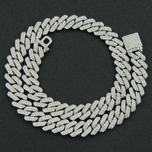 Macro detail of iced-out silver Cuban link chain with encrusted pavé diamonds and box clasp