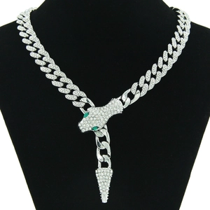 Détail de la chaîne cubaine argentée avec tête de serpent sertie de diamants et yeux verts