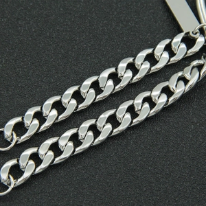 Polished silver Cuban link steel bracelet with rectangular charm on black texture
