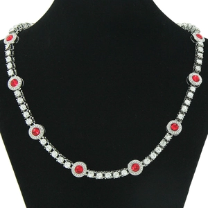 Dettaglio della collana argentata con pietre rosse tonde e cristalli bianchi pavé