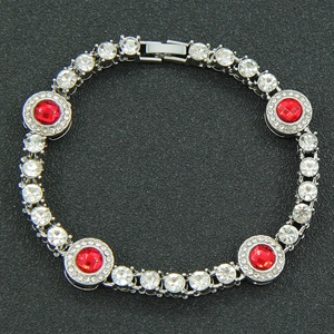 Dettaglio del bracciale color argento con quattro pietre rosse centrali sfaccettate