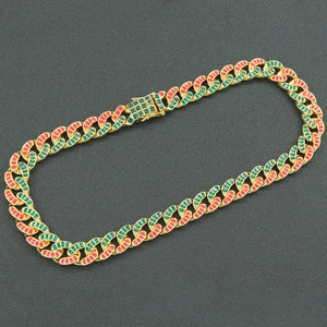 Collana a catena cubana dorata con smalto rosso e verde su sfondo nero opaco
