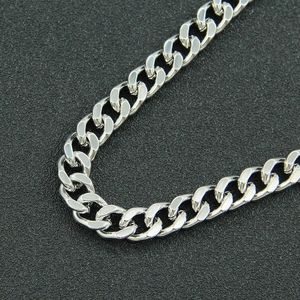 Close-up of polished silver Cuban link chain with high-gloss finish on black background