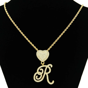 Detail of gold Cuban rope chain with iced out heart clasp and letter R pendant