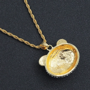 Macro shot of gold bear pendant back featuring matte frosted texture and twisted chain