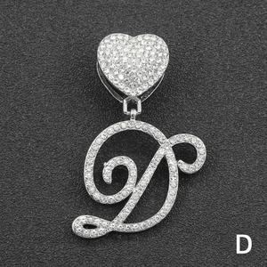 Macro shot of silver hip-hop pendant with iced out heart and cursive D letter detail