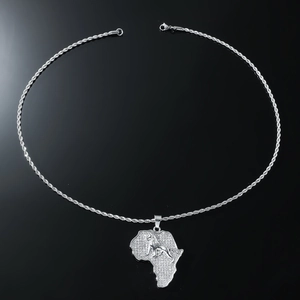 Macro detail of silver iced-out Africa map pendant with a 3D lion head and rope chain