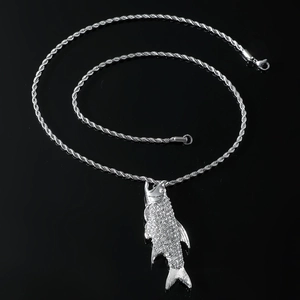 Detailed macro view of a silver fish pendant with sparkling rhinestones on a twist chain