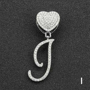 Close-up of iced out letter J pendant with heart clasp and silver rhinestones