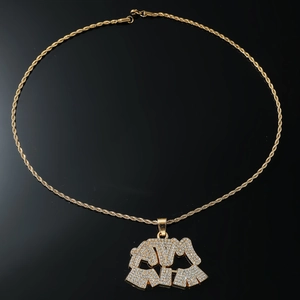 Macro view of gold plated iced-out ATM letter pendant on a twisted rope chain necklace