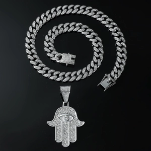 Détail du pendentif main de Hamsa argenté serti de diamants sur une grosse chaîne cubaine