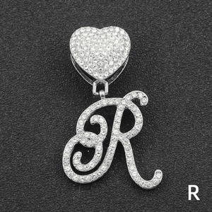 Close-up of hip hop silver letter R pendant with full diamond paving and heart clasp
