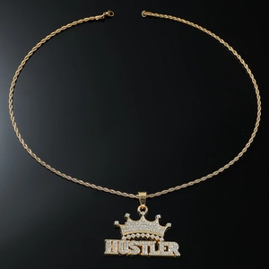 Macro detail of iced-out HUSTLER letter pendant with crown and gold rope chain