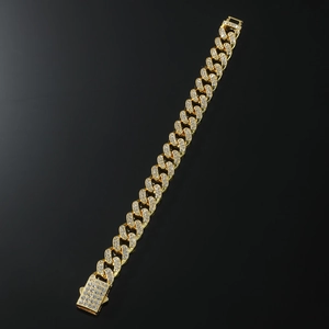 Dettaglio di bracciale cubano dorato con cristalli pavé e chiusura a scatto quadrata