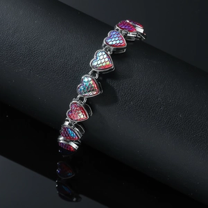 Chunky rhinestone heart bracelet with iridescent scales on black display