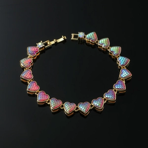 Detail of gold heart link bracelet with rainbow scale texture and iridescent stones