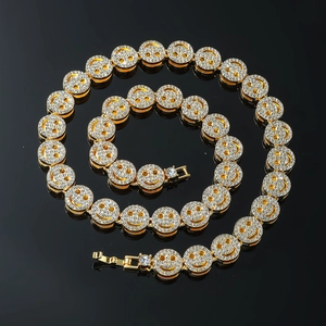 Detailansicht der goldene Cuban-Kette mit glitzernden Smiley-Anhängern im Hip-Hop-Stil
