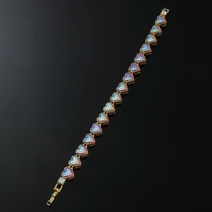 Close-up of golden heart chain bracelet with colorful iridescent scale texture detail